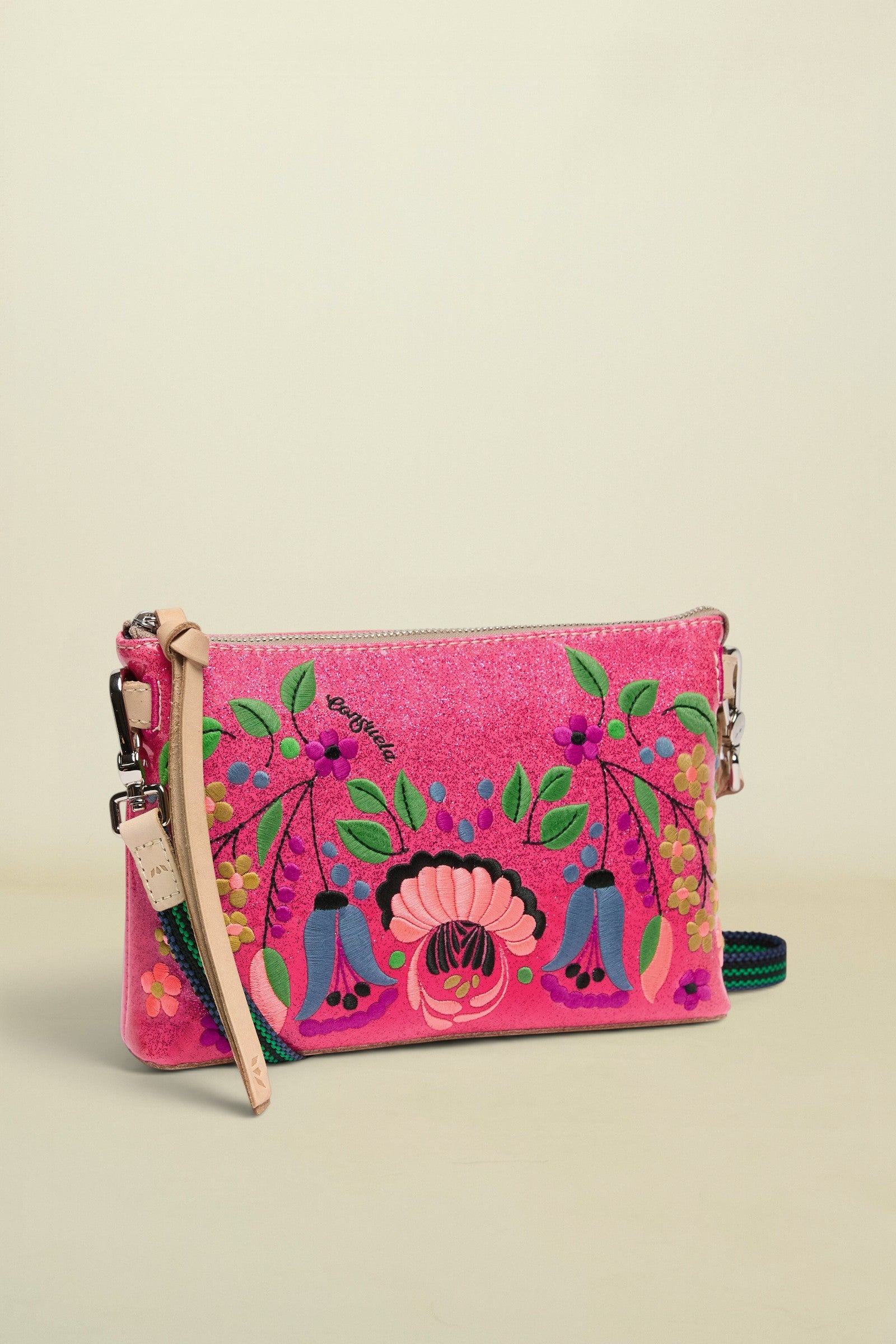 Pink clutch with colorful floral and figure design on a white background