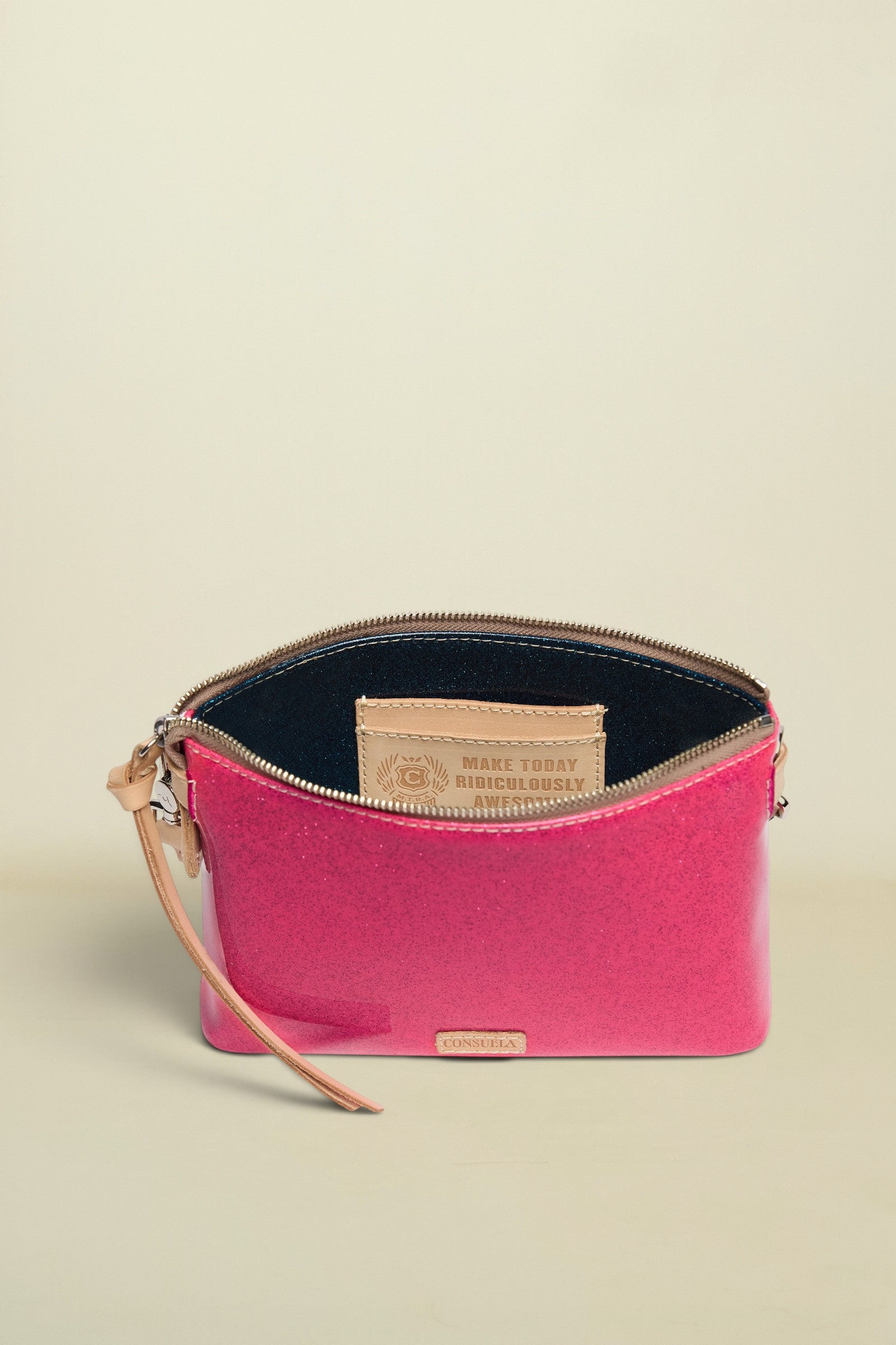 Pink clutch bag with beige strap and visible brand logo on a white background