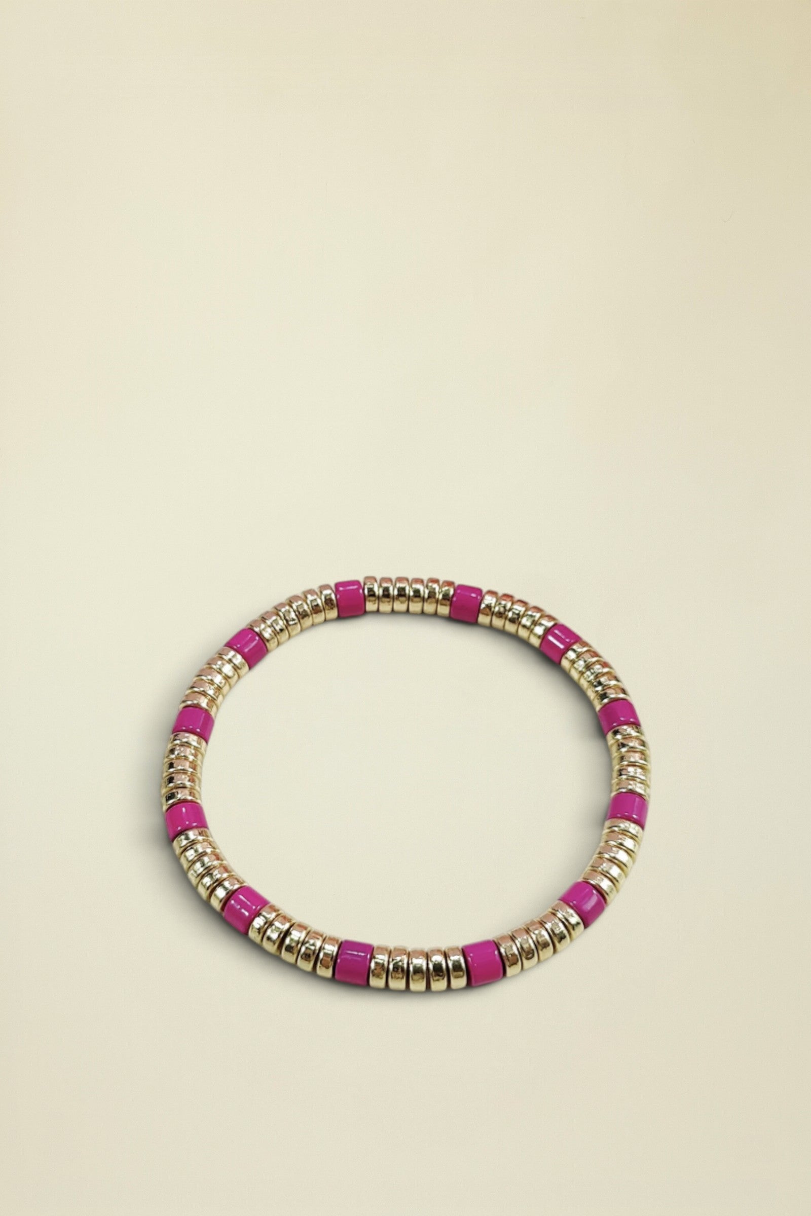 Bracelet with pink and gold beads on a white background