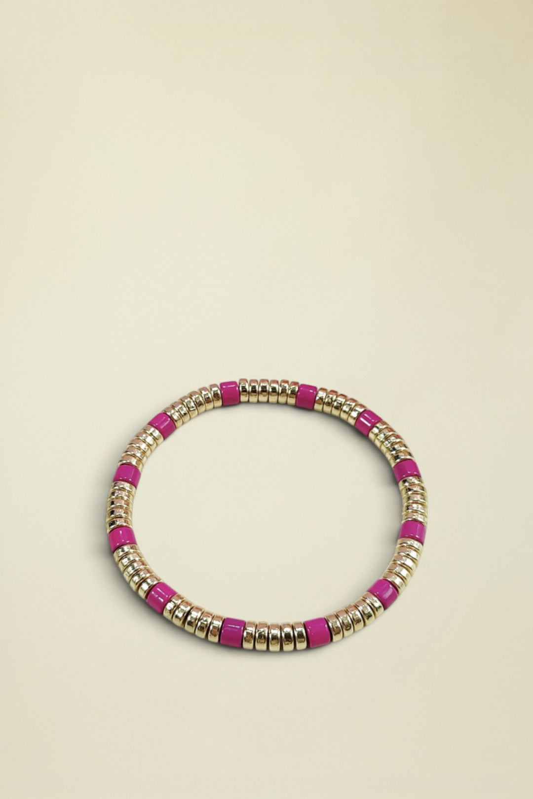 Bracelet with pink and gold beads on a white background