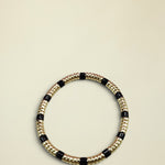 Bracelet with gold and black beads on a white background