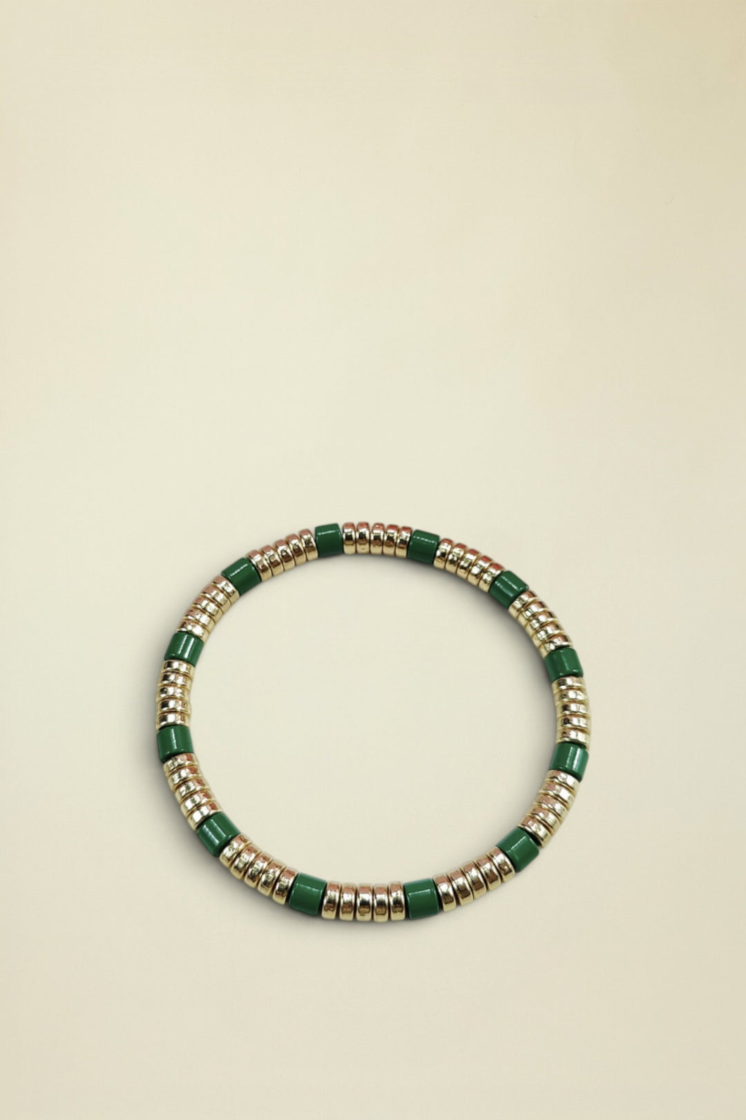 Bracelet with green and gold beads on a white background
