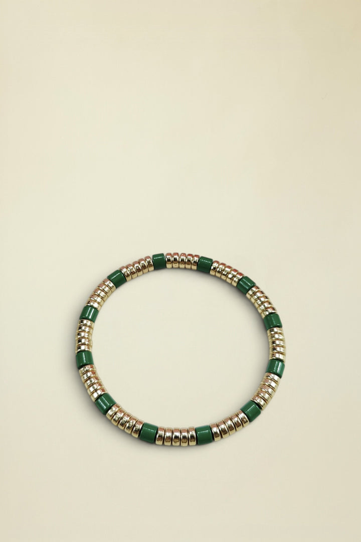 Bracelet with green and gold beads on a white background