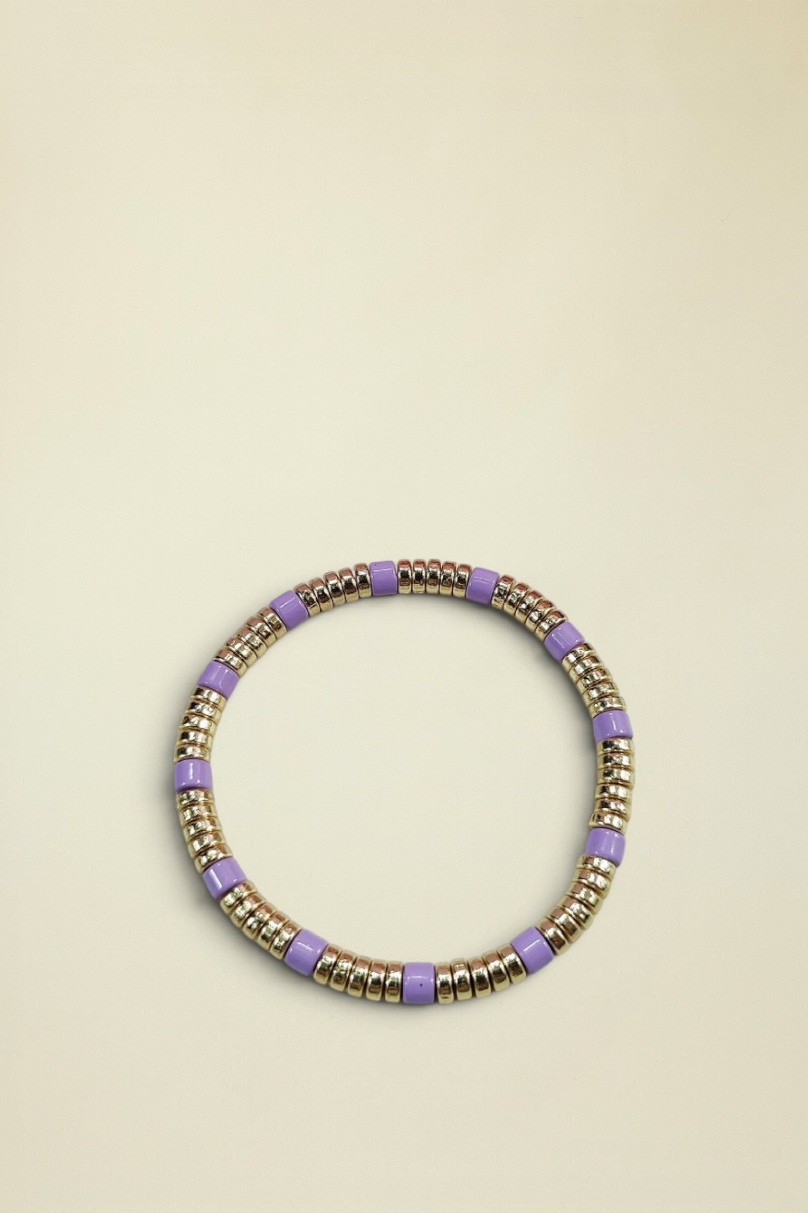Bracelet with gold and purple beads on a light gray background