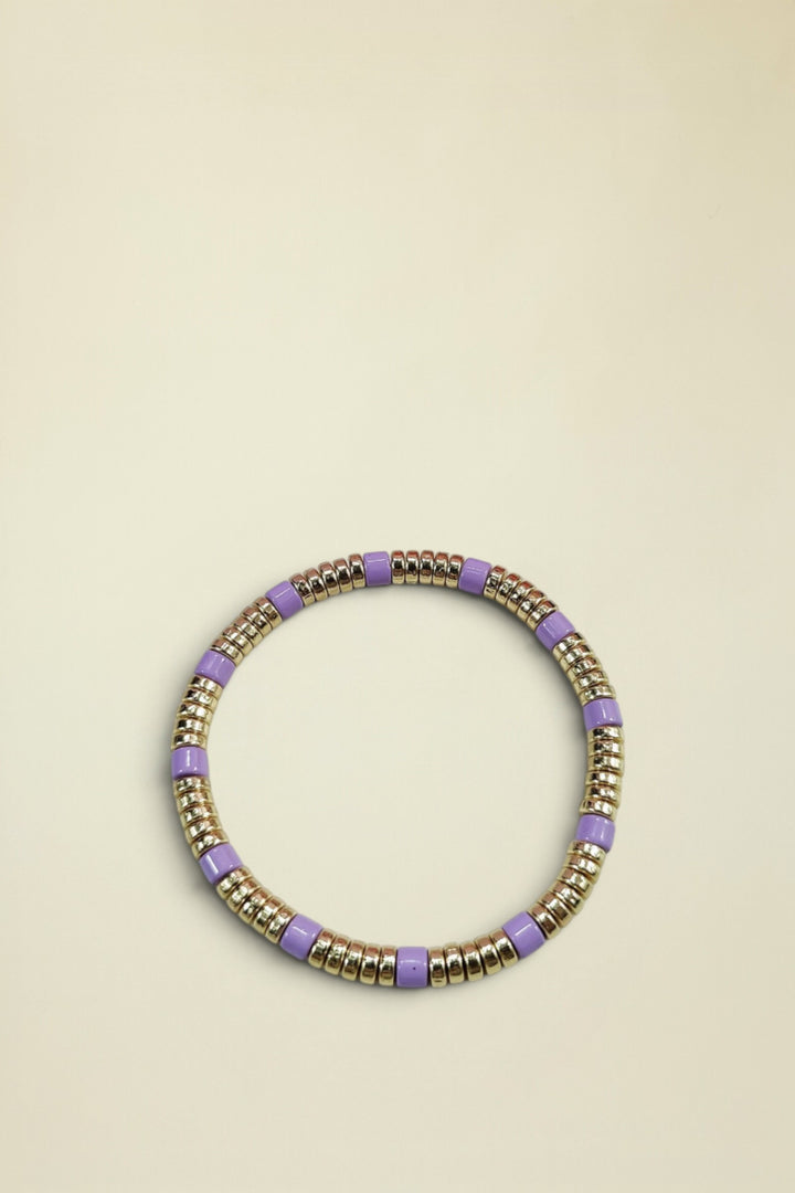 Bracelet with gold and purple beads on a light gray background