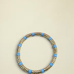 Bracelet with gold and blue beads on a white background