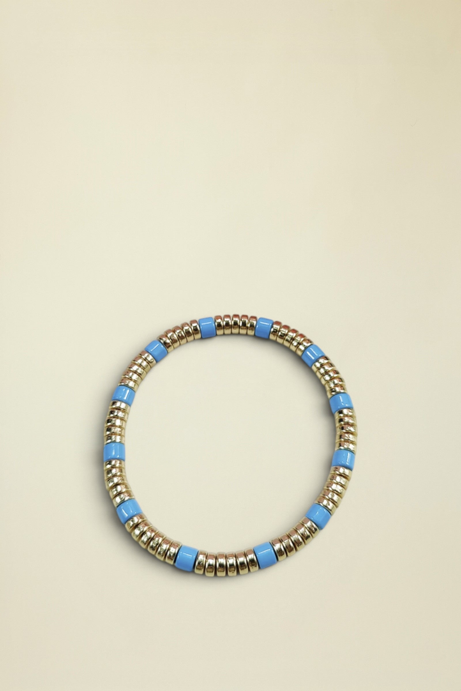 Bracelet with gold and blue beads on a white background