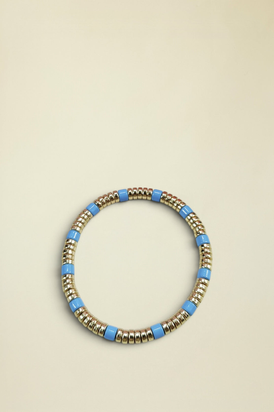 Bracelet with gold and blue beads on a white background
