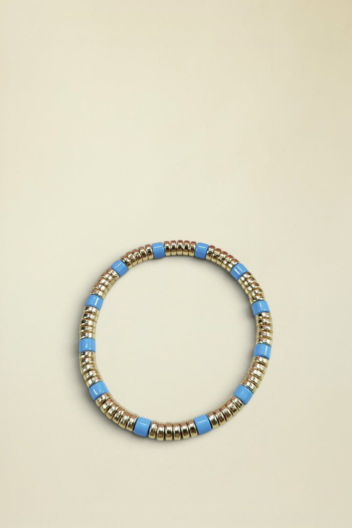 Bracelet with gold and blue beads on a white background