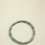 Bracelet with gold and turquoise beads on a white background