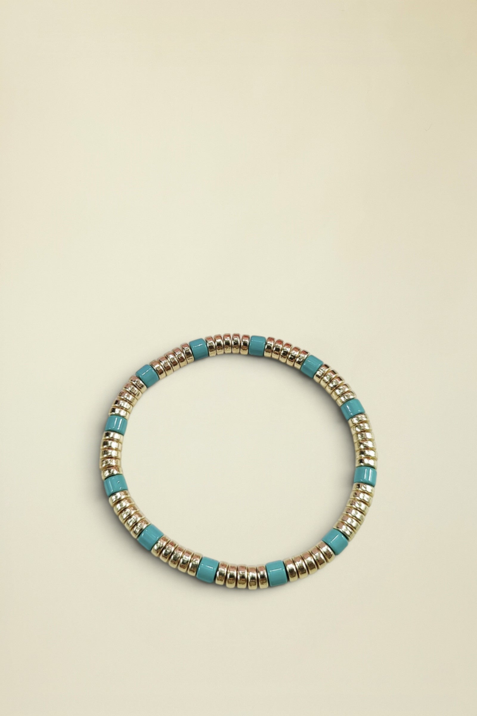 Bracelet with gold and turquoise beads on a white background