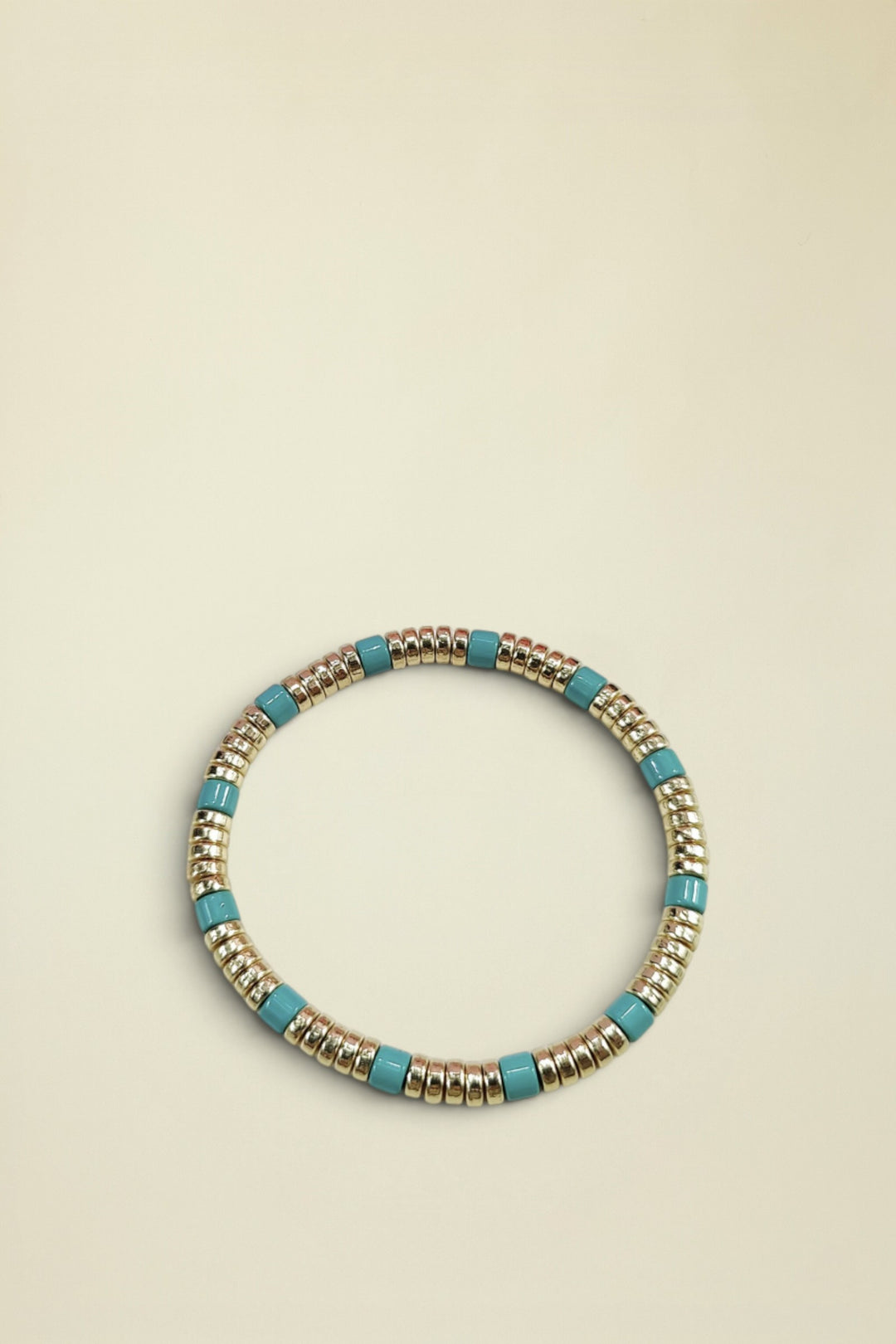 Bracelet with gold and turquoise beads on a white background
