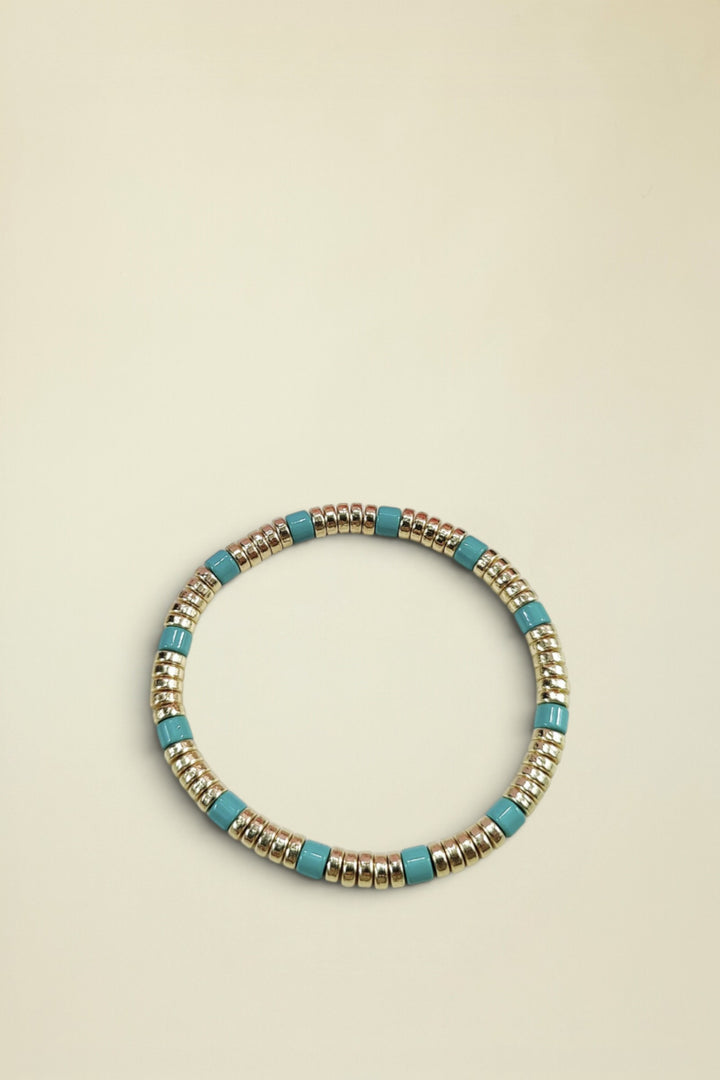 Bracelet with gold and turquoise beads on a white background