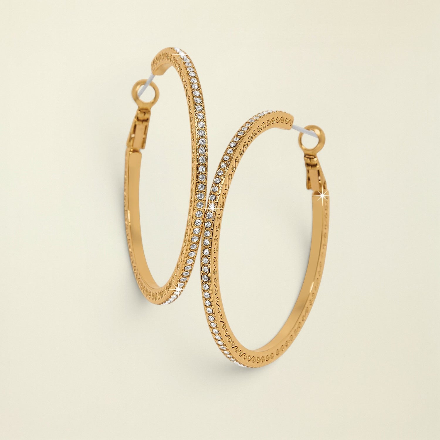 Gold hoop earrings with embedded stones on a white background