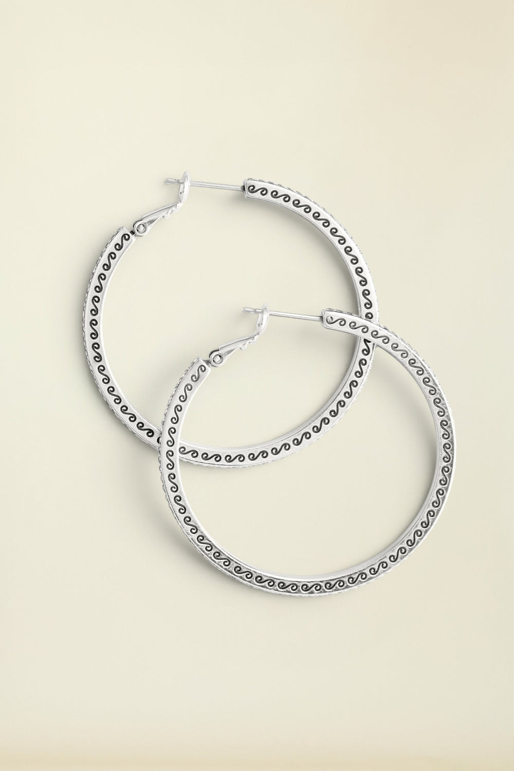 Meridian Thin Large Hoop Earrings laying on neutral background