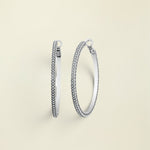 A pair of silver hoop earrings with fine crystal pave details, displayed against a white background.