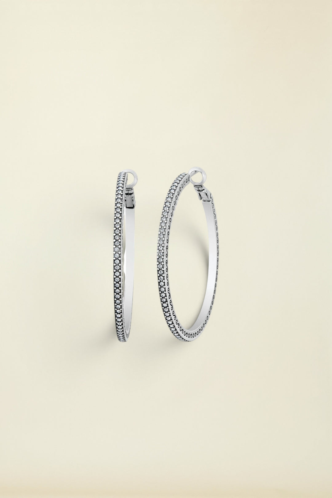 A pair of silver hoop earrings with fine crystal pave details, displayed against a white background.