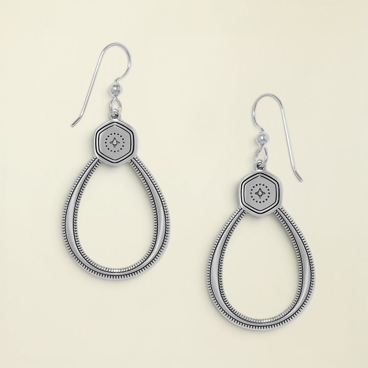 Pair of silver earrings with hexagonal design on a white background
