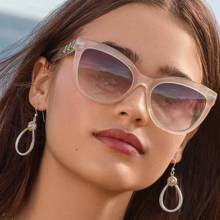 Close-up of a woman wearing sunglasses with a blurred beach background