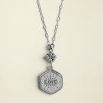 Silver necklace with a 'LOVE' pendant on a white background