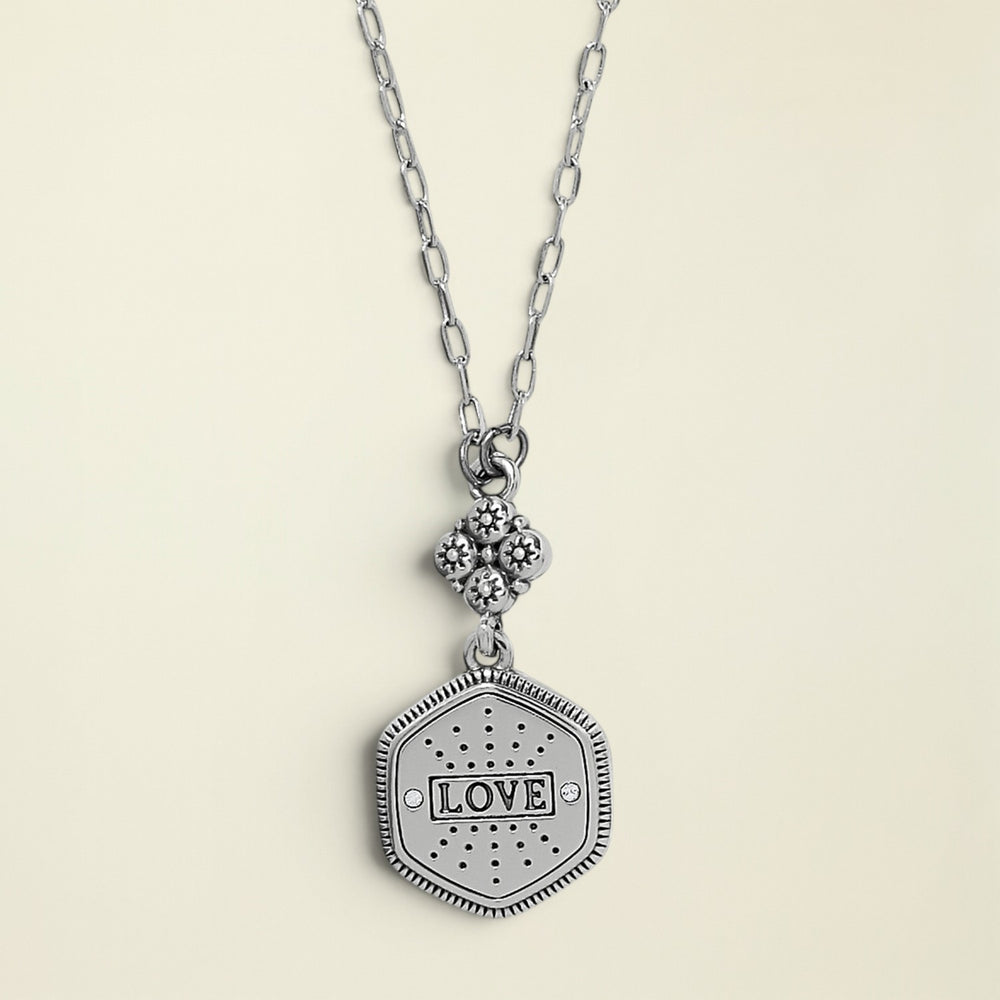 Silver necklace with a 'LOVE' pendant on a white background