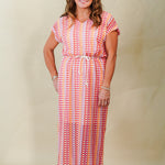 Woman wearing a patterned dress against a plain background