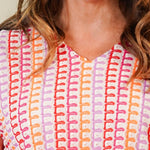 Woman wearing a patterned dress against a plain background