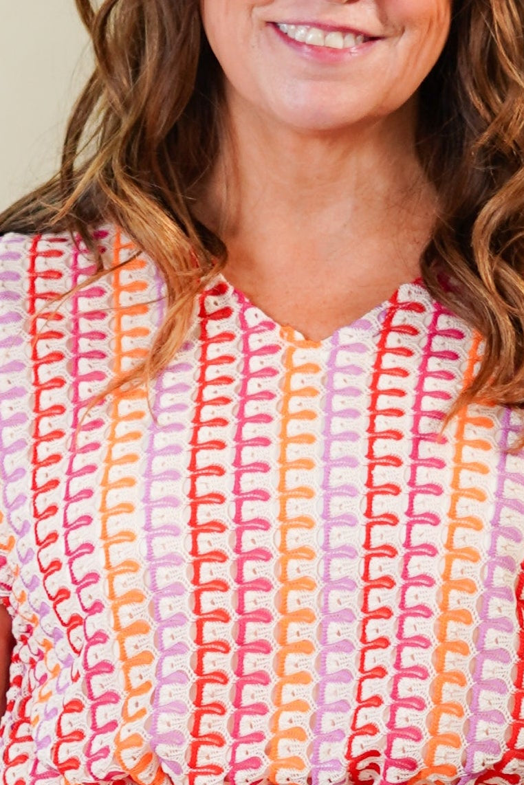 Woman wearing a patterned dress against a plain background
