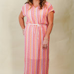 Woman wearing a patterned dress against a plain background