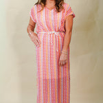 Woman wearing a colorful patterned dress against a plain background