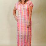 Woman wearing a long, patterned dress against a plain background