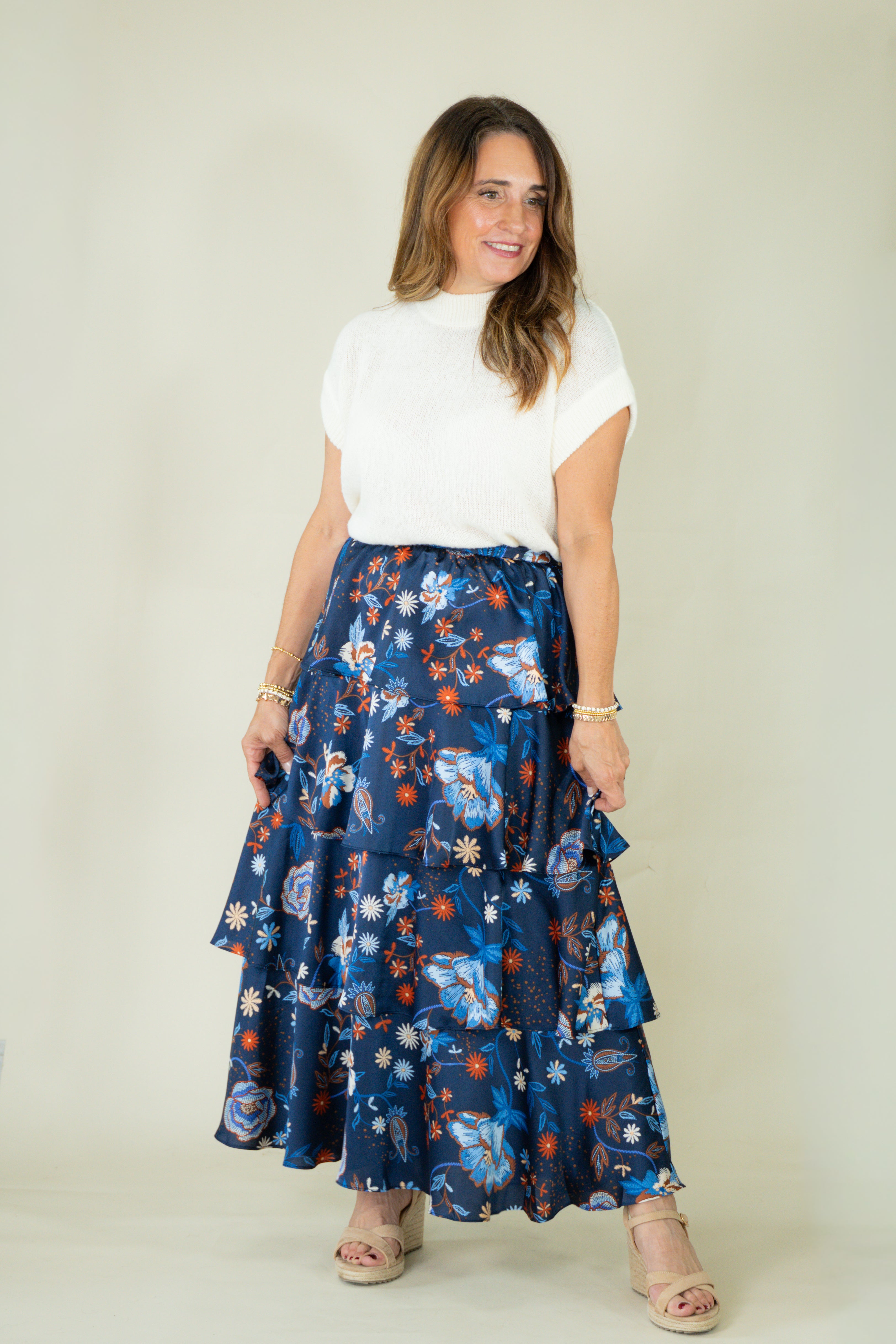 Woman wearing navy floral tiered ruffle maxi skirt with white top