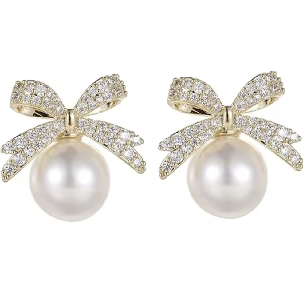 Bow-shaped earrings with pearl centers on a white background