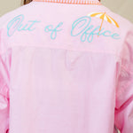 Person wearing a pink dress with text and graphics on the back against a plain background