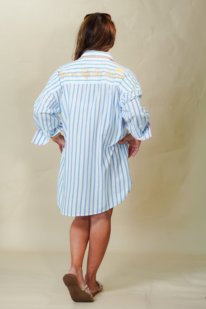 Person wearing a blue and white striped dress with text on a plain background