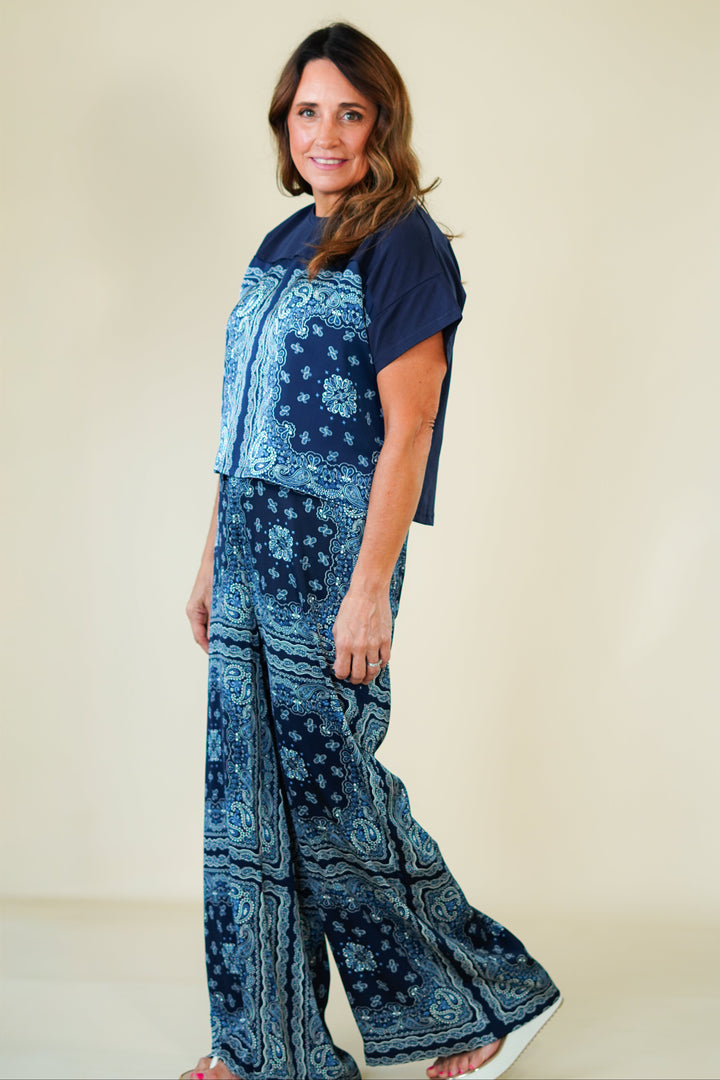 Woman wearing a blue patterned outfit on a beige background