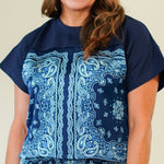 Woman wearing a blue patterned outfit against a plain background