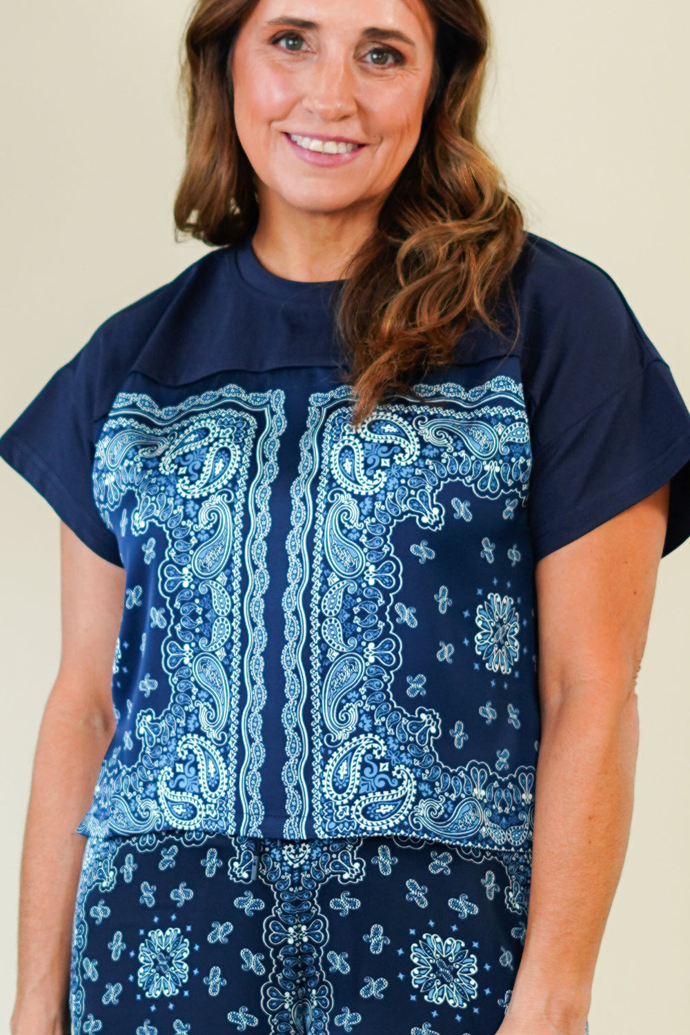 Woman wearing a blue patterned outfit against a plain background
