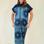 Woman wearing a blue patterned outfit on a plain background