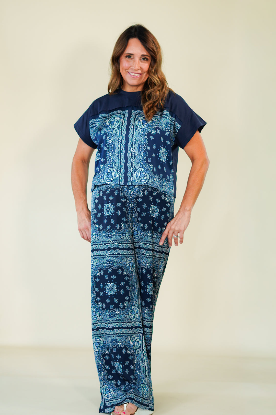 Woman wearing a blue patterned outfit on a plain background