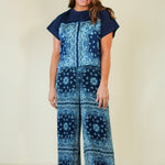 Woman wearing a blue patterned outfit on a plain background