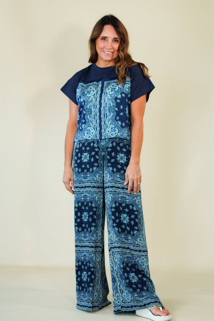 Woman wearing a blue patterned outfit on a plain background