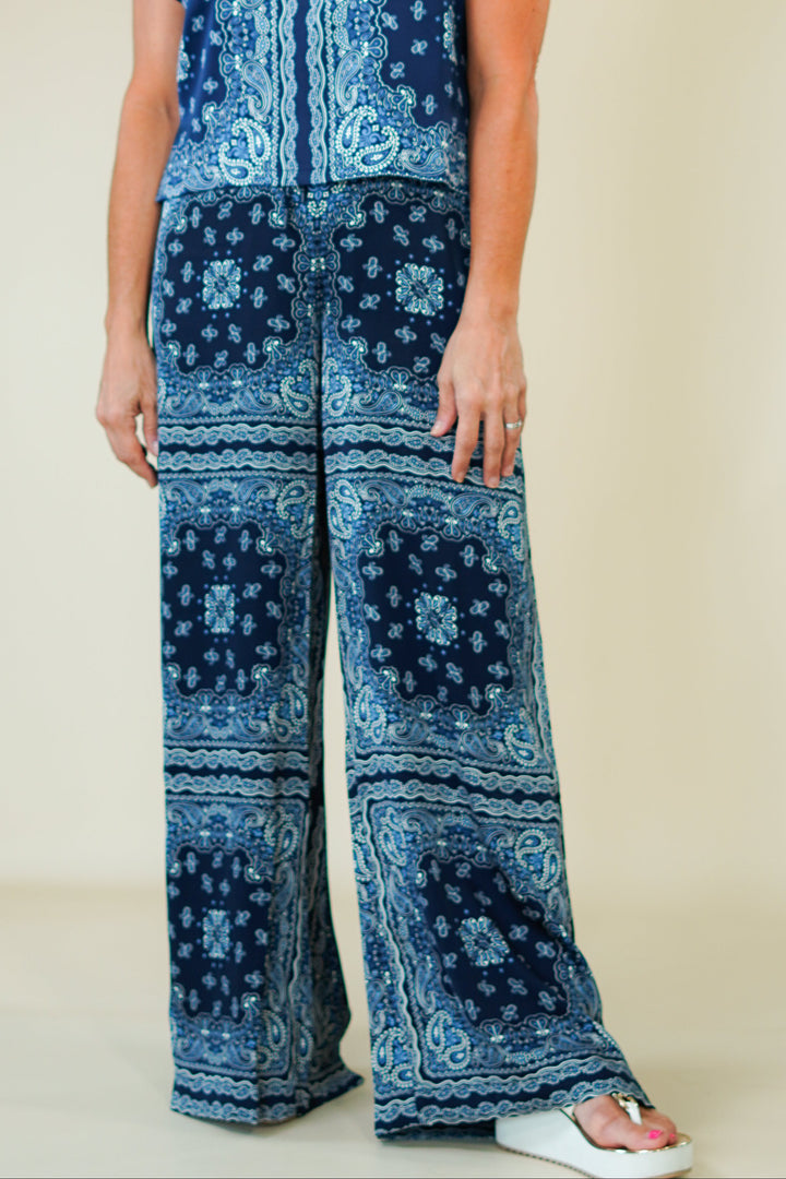 Woman wearing a blue patterned outfit on a plain background