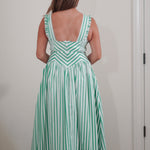 Woman wearing a green and white striped dress against a plain background
