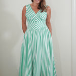 Woman wearing a green and white striped dress against a plain background