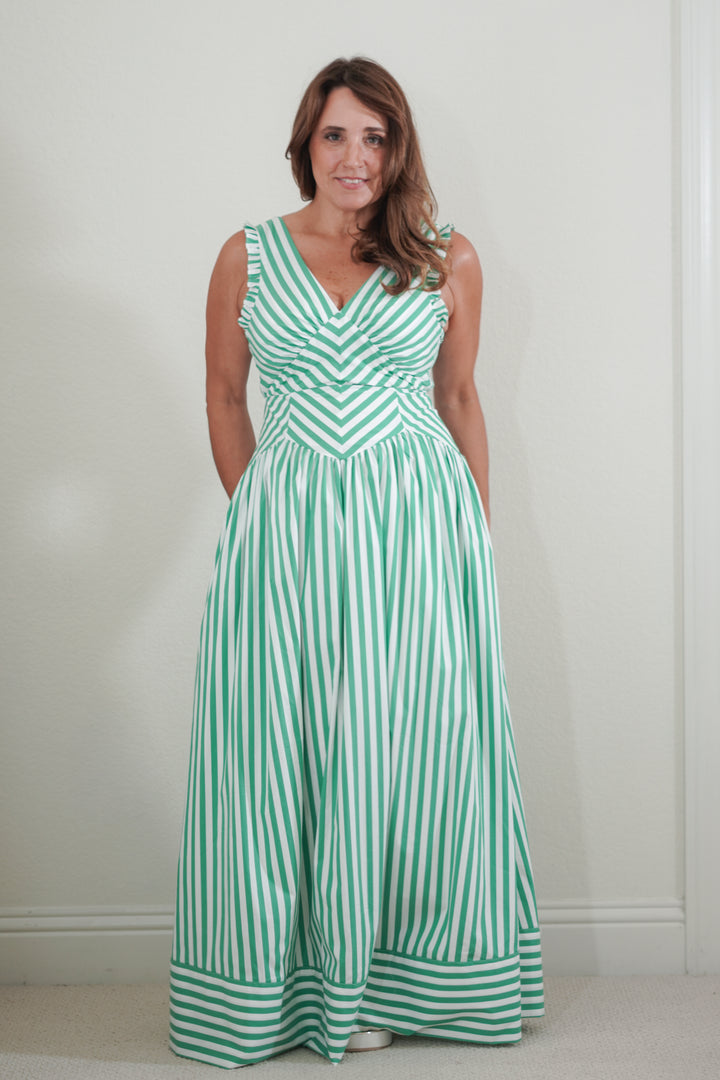 Woman wearing a green and white striped dress against a plain background