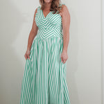 Woman wearing a green and white striped dress against a plain background