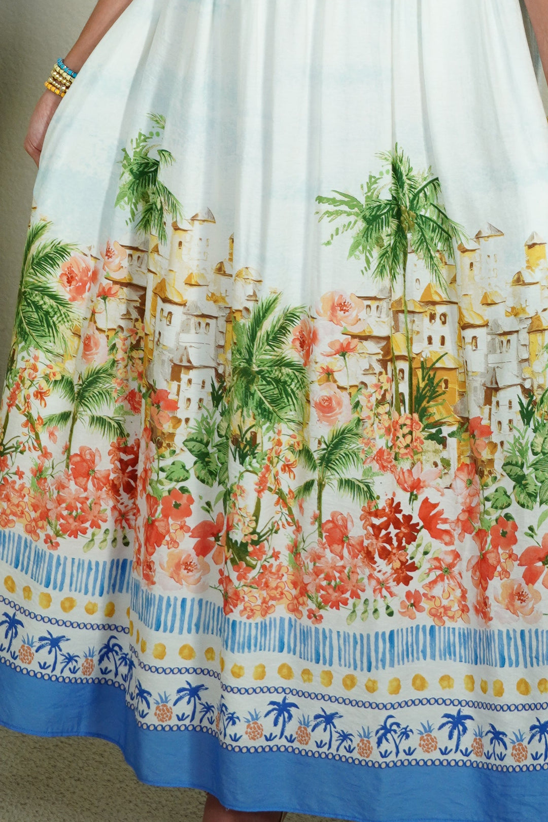 Woman wearing a colorful dress with a scenic print indoors.