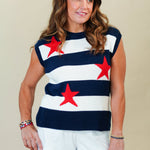 Woman wearing a sleeveless top with red star patterns and white shorts on a beige background