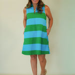 Woman wearing a green and blue striped dress against a plain background